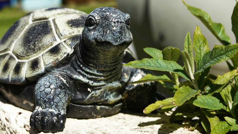 Elegant stone garden ornaments surrounded by blooming perennials and soft greenery